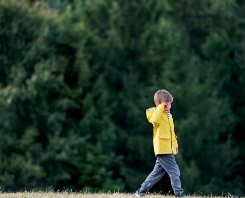 A child is walking while being disappointed.
