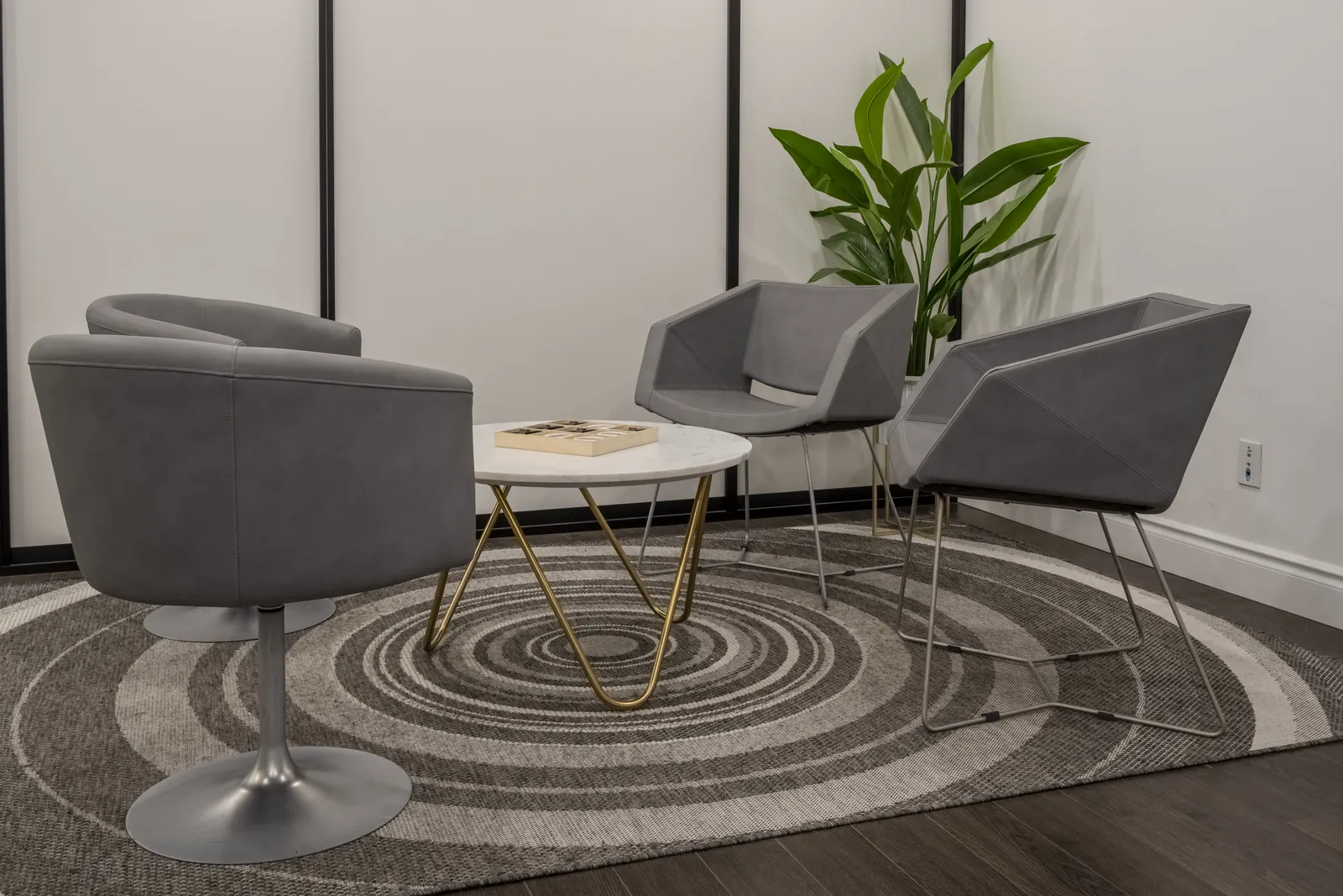 Waiting area at the Toronto Family Therapy North York office, with grey armchairs around a round marble table